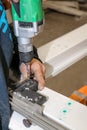 A man fixes an element for the realization of PVC window frames in a carpentry