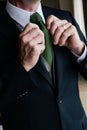 Man fixes tie in a suit Royalty Free Stock Photo