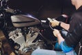 Man fixing bike. Confident young man repairing motorcycle near his garage. barometer