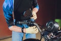 Man fixing bike. Confident young man repairing motorcycle near his garage. rearview mirror adjustment.