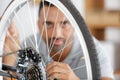 man fixing bike wheel in store