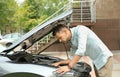 Man fixing broken car