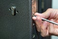 Man fixing the door with screwdriver. Door lock repair