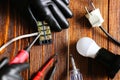 a man fixing an electric lamp, dielectric gloves, a screwdriver. Wire connector, top view, wood background.