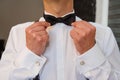 Man fixing his bow tie. Man groom in wedding suit with a bow tie. Close-up Royalty Free Stock Photo