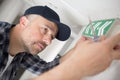 man fixing illuminated exit sign to wall