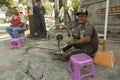 Man fixing scooter wheel in Phnom Penh