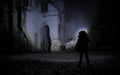 A man with a flashlight near the ruins of an old castle