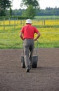 Man flattening the soil for preparing garden lawn