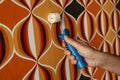 man flatting the seams of a wallpapered wall