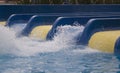The man flew with great speed from the blue water slide into the pool