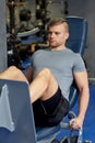 Man flexing leg muscles on gym machine Royalty Free Stock Photo