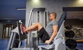 Man flexing leg muscles on gym machine Royalty Free Stock Photo