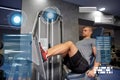 Man flexing leg muscles on gym machine Royalty Free Stock Photo