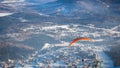 Man flies with an orange parachute Royalty Free Stock Photo