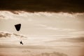 Man flying a paraglider against the clouds