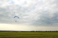 Man flying a paraglider against the clouds