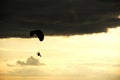 Man flying a paraglider against the clouds