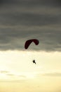 Man flying a paraglider against the clouds