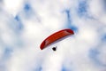 Man flying a paraglider against the clouds