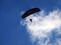 Photo of a man flying a parachute wing against a blue sky and clouds Royalty Free Stock Photo