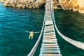 man floating in sea water on back. bay with rocky beach and suspension bridge Royalty Free Stock Photo