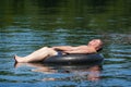 Man Floating in Water on Inner Tube