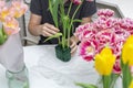 A man florist collects a bouquet of tulips using a sponge