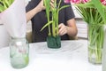 A man florist collects a bouquet of tulips using a sponge