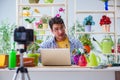 The man florist gardener vlogger blogger shooting video on camera