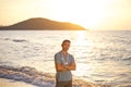 A man  with a flower garland on his neck near the sea in the rays of the sun Royalty Free Stock Photo