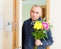 Man with flowers near door Royalty Free Stock Photo