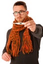 Man with flu and fever wrapped in scarf holding thermometer.