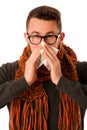 Man with flu and fever wrapped in scarf sneezing into handkerchi