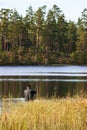 Man fly fishing at a forest lake Royalty Free Stock Photo