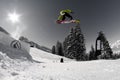 A man flying through the air while riding a snowboard down a snowy hill Royalty Free Stock Photo