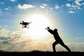 Man flying drone against setting sun Royalty Free Stock Photo