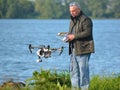 Man flying Drone, Drone in picture, water in background.