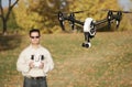 Man Flying A High-Tech Camera Drone (Fall Trees & Leaves in Background)