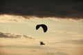 Man flying a paraglider against the clouds