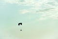 Man flying a paraglider against the clouds