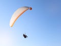 Man flying on a paraglider on the blue sky background