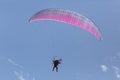 Man flying motorized parasail in blue sky with small puffy clouds Royalty Free Stock Photo