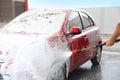 Man foaming red auto at car wash