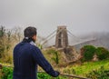 Man in focus looking at famous Clifton bridge in Bristol Royalty Free Stock Photo