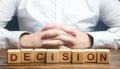 Man folded his hands on a background of blocks with the word Decision. Make the right decision, the answer to the question