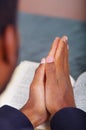 Man folding hands praying with open bible lying in front, seen from behind models head, religion concept Royalty Free Stock Photo