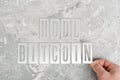 Man folds the inscription hodl bitcoin from metal plates.