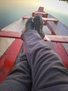 Man foot on traditional wood boat at calm lake at calm lake Royalty Free Stock Photo