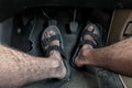 Man foot using sleeve on three driving pedal with a manual transmission. Clutch, brake, accelerator of a car